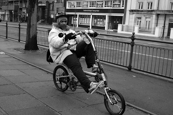 A rider on a recumbent bike looks into the camera